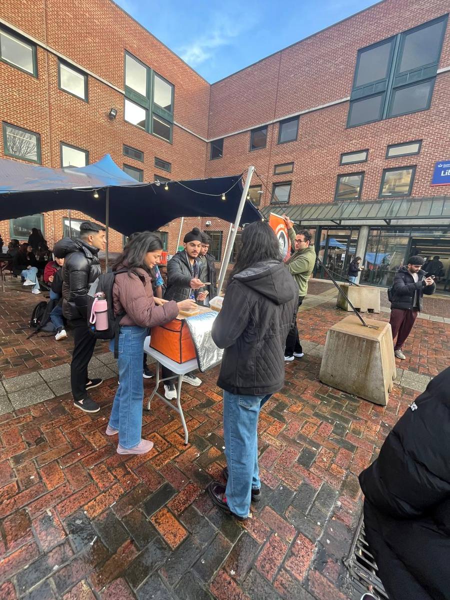 Outdoor stall on campus distributing free food as part of the cost-of-living campaign